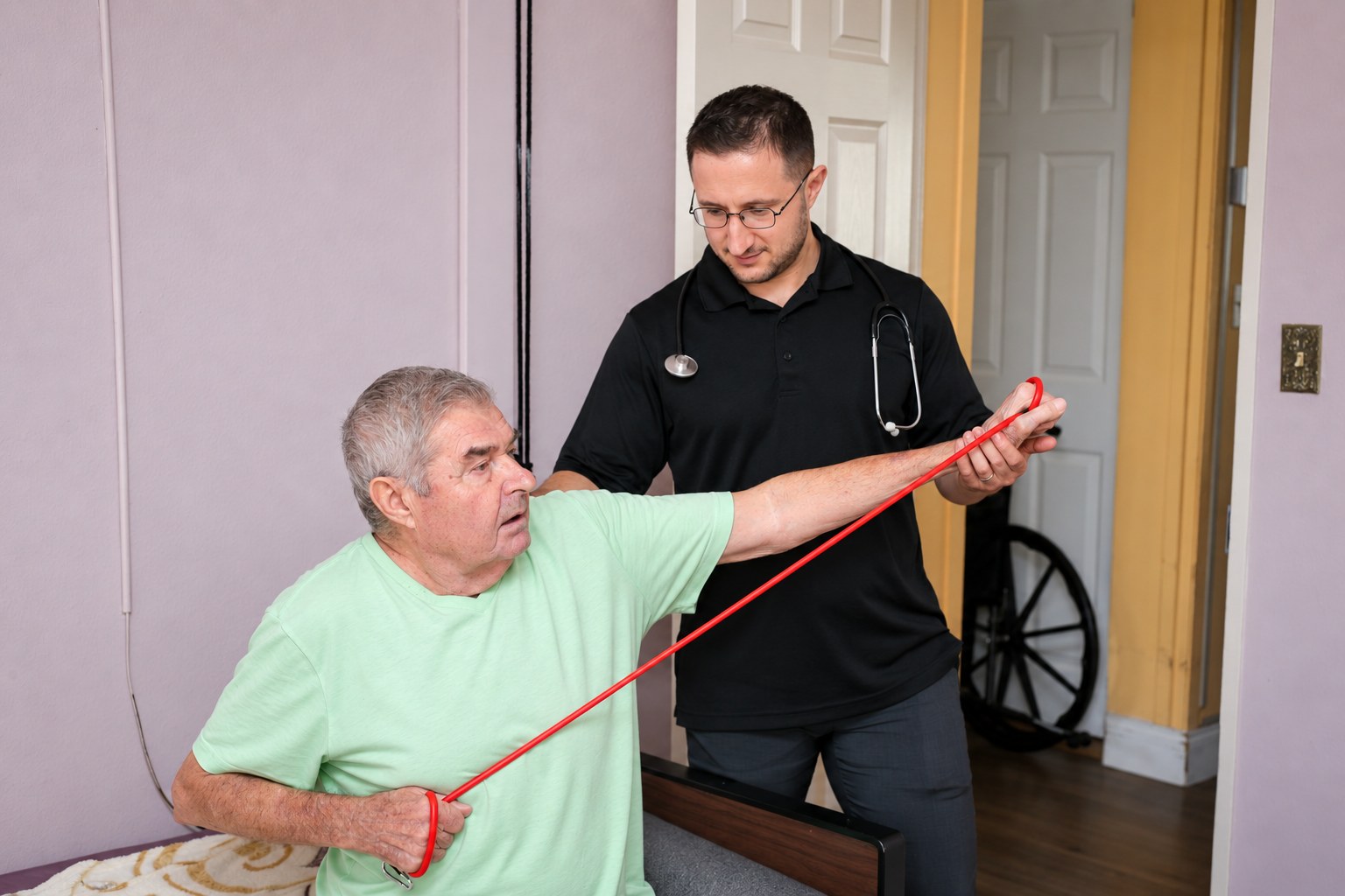 Dr. Lenny guiding a seated patient through a resistance-band movement at home