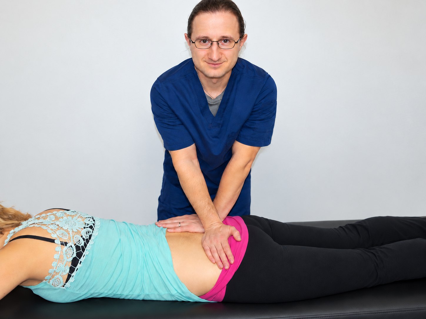 Dr. Lenny in navy scrubs providing hands-on physical therapy during an in-home visit