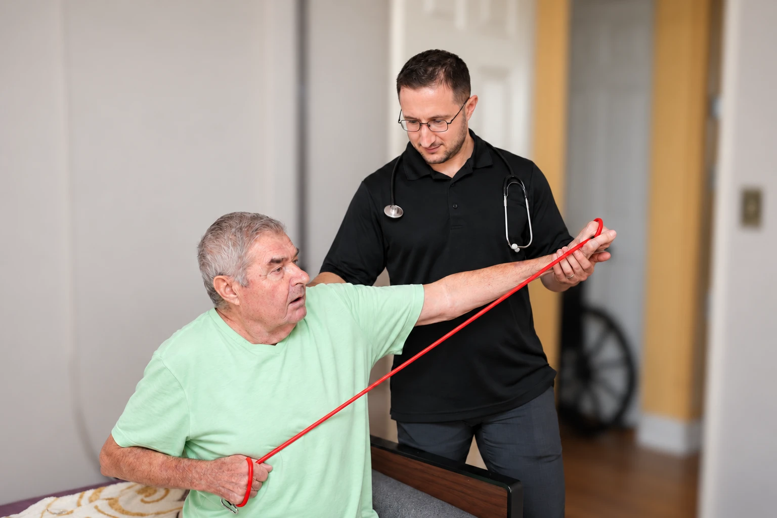 Dr. Lenny guiding a seated client through a resistance-band exercise at home